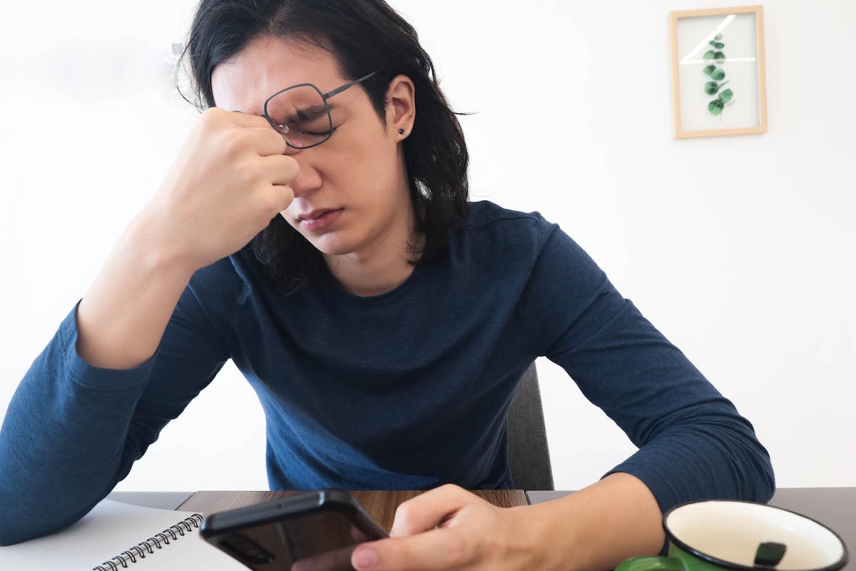 man experiencing eye strain from phone screen