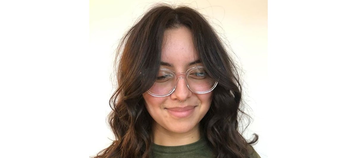 woman with long side bangs wearing clear glasses frames