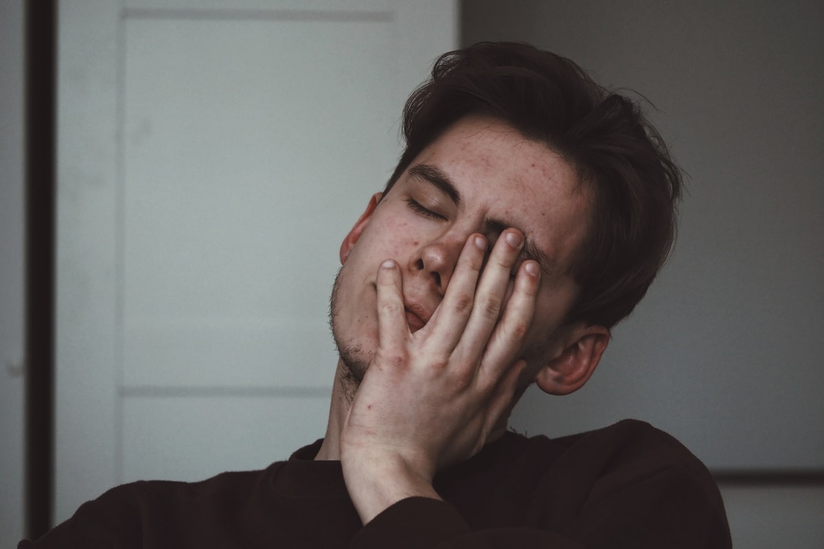 man covering left eye due to eye strain