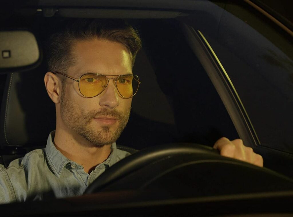 man wearing glasses driving at night