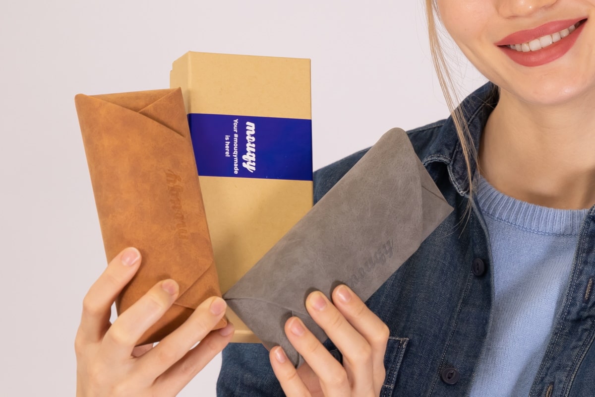 woman holding mouqy eyeglasses pouches and box