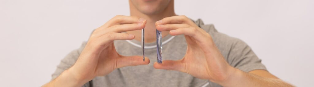 man holding two pieces of glasses lenses side by side