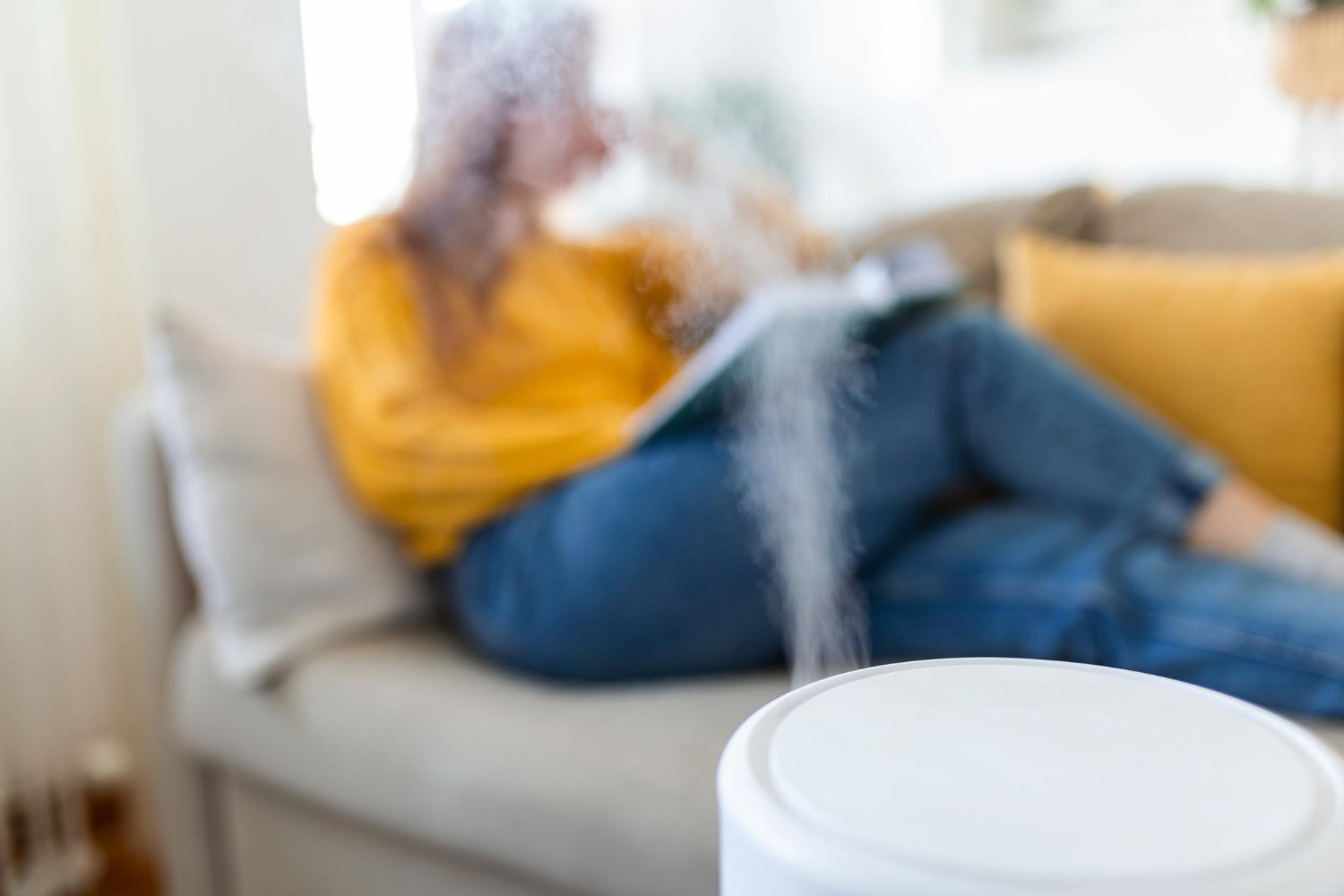 woman reading book with a humidifier on to alleviate itchy eyes