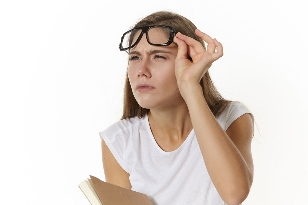 woman taking off glasses and has blurred vision should seek immediate medical help