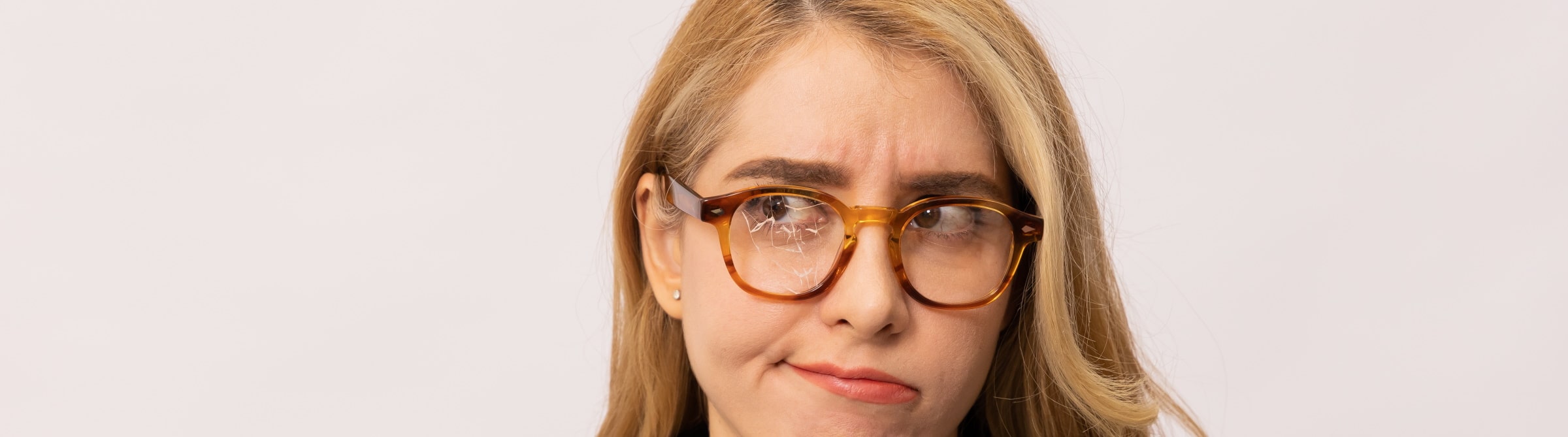 unhappy woman wearing glasses with cracked lens