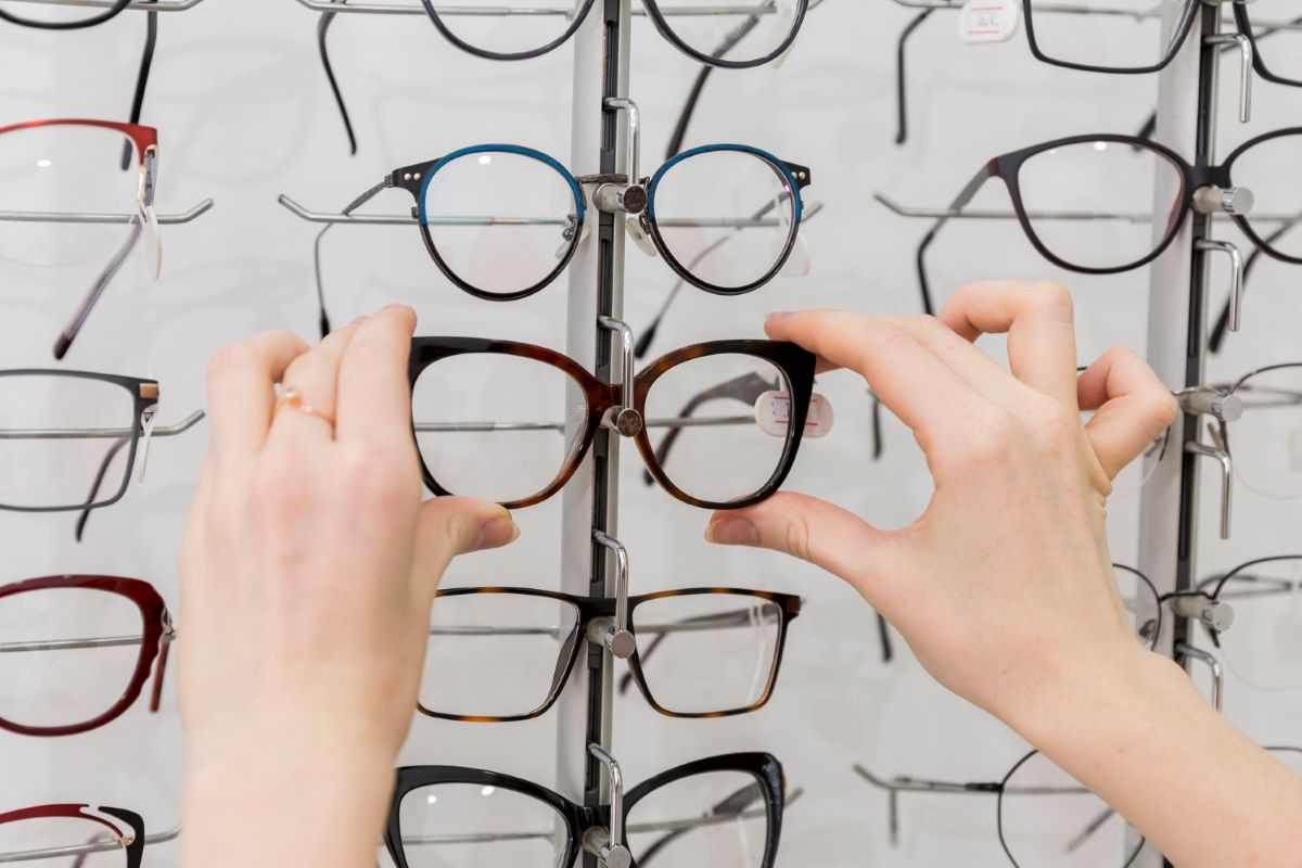 woman hand removing eyeglasses from display