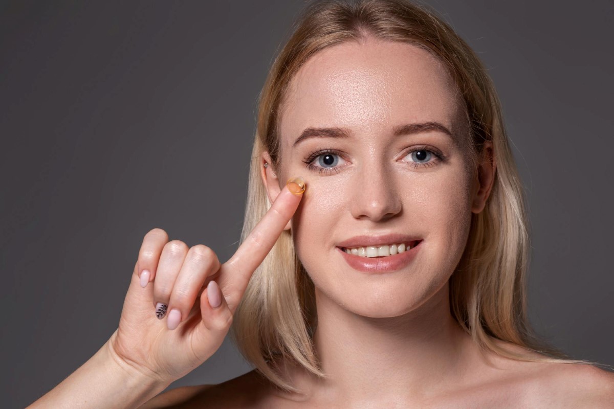 woman holding contact lens on index finger