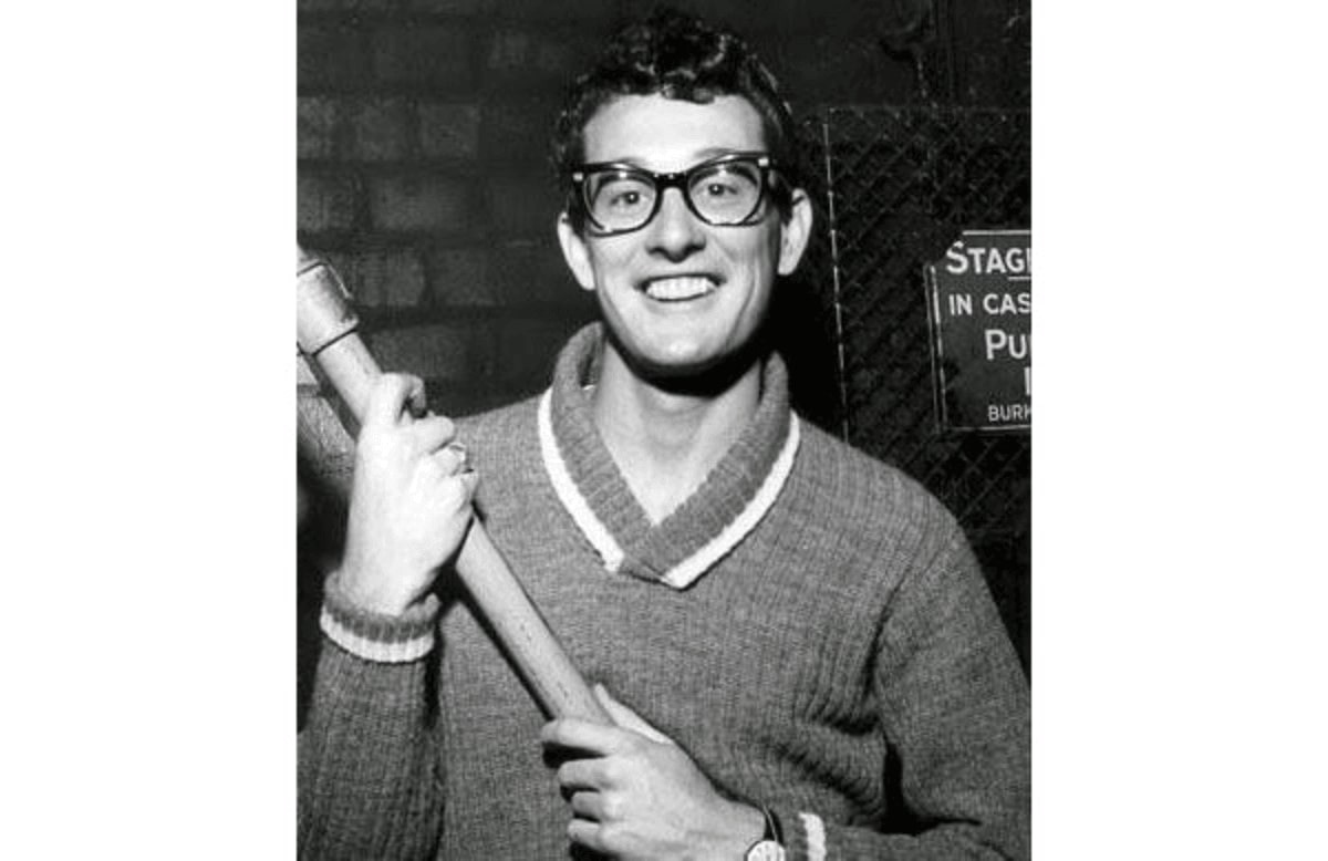 Buddy Holly wearing a pair of glasses posing for a photo in between rehearsals in 1958
