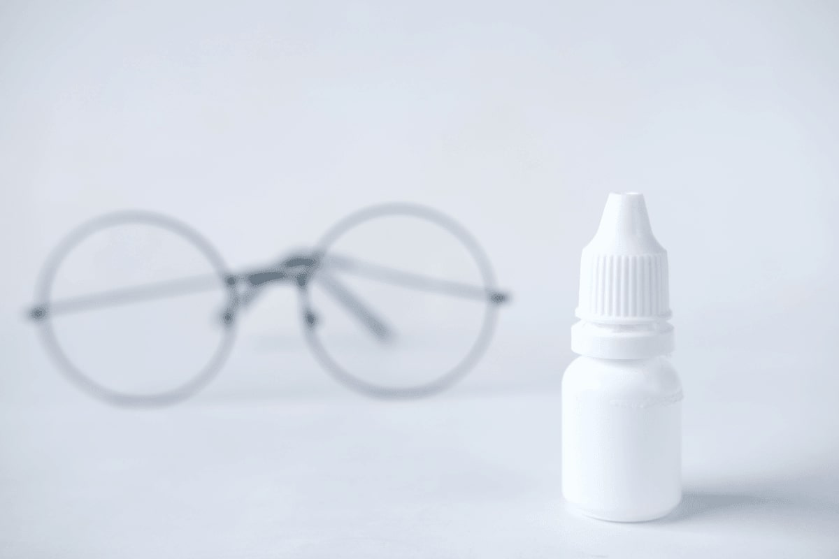 a pair of eyeglasses and a bottle of eyedrop