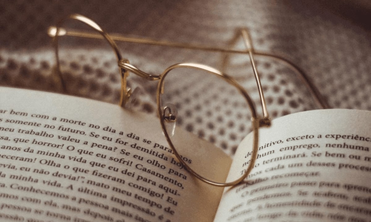 a pair of eyeglasses placed on top of an opened book