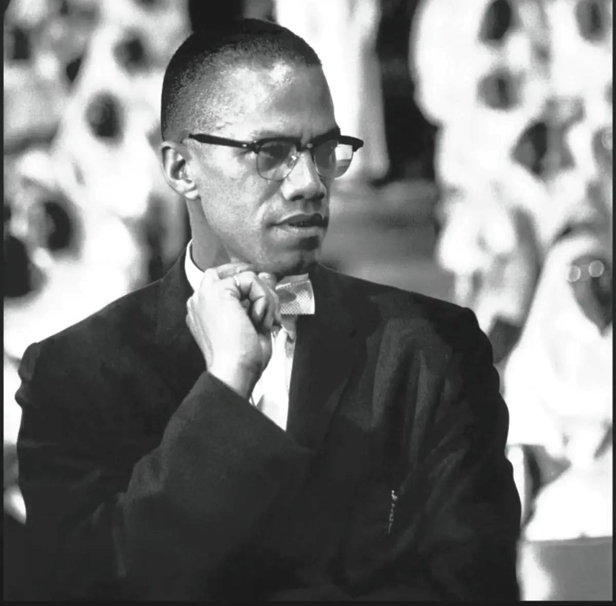 malcolm x in his browline glasses suit and bowtie