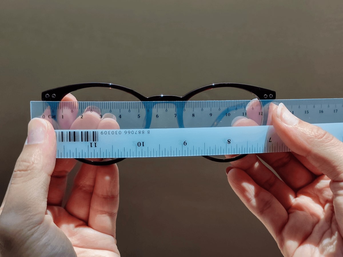 measuring a glasses frame width with a millimeter ruler