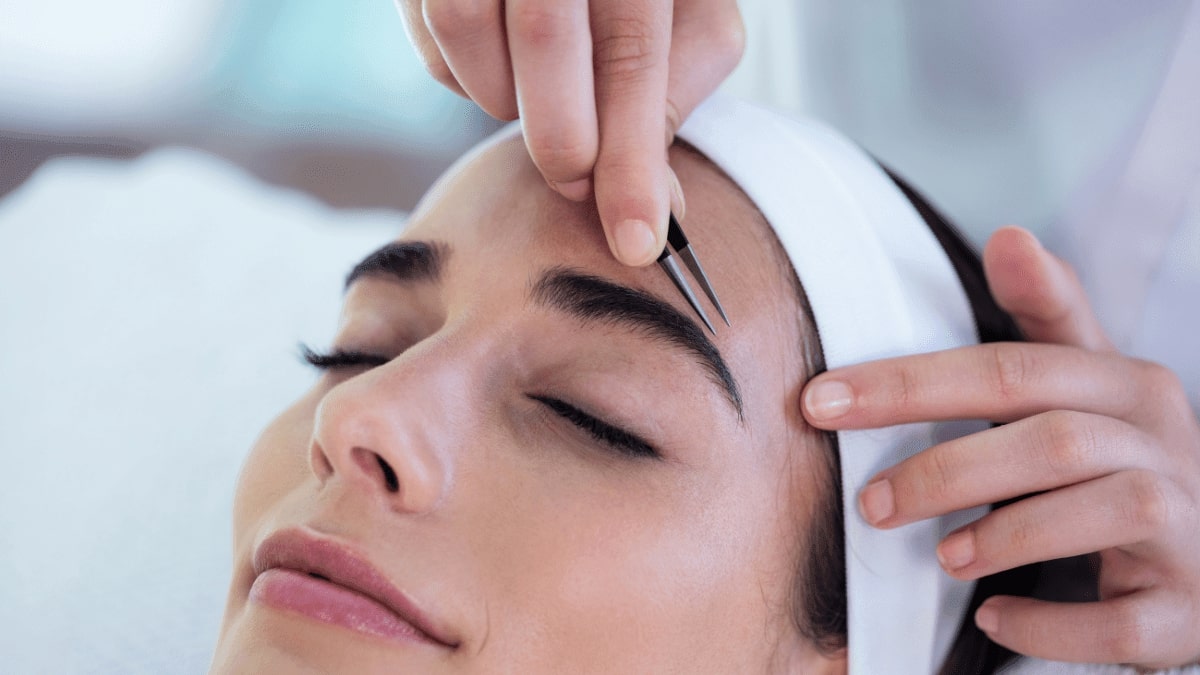 woman plucking eyebrows