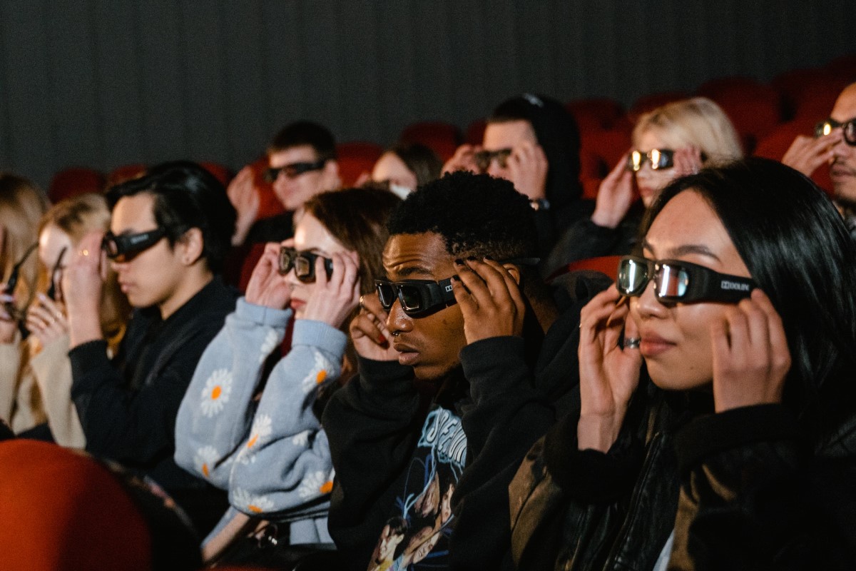movie goers watching 3d movie while wearing 3d glasses in a cinema