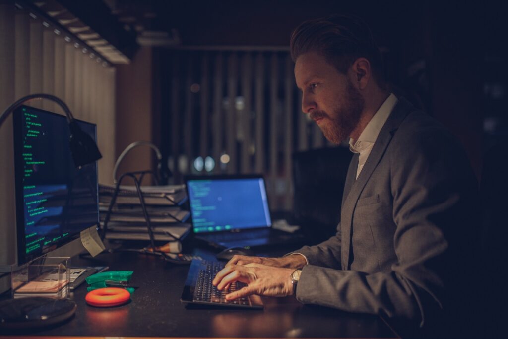 man working on a computer in dark mode