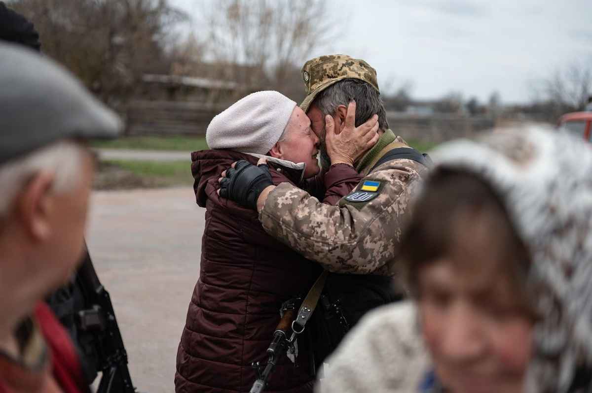 an elderly couple hugging while crying