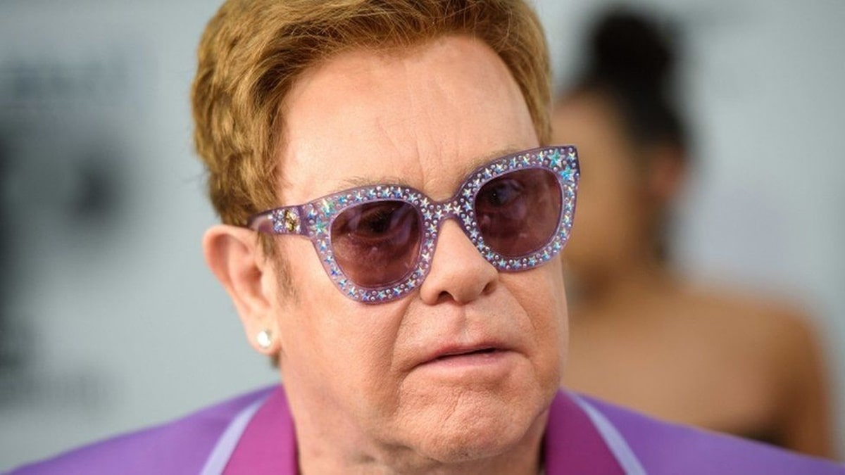 elton john wearing a pair of purple cat eye glasses