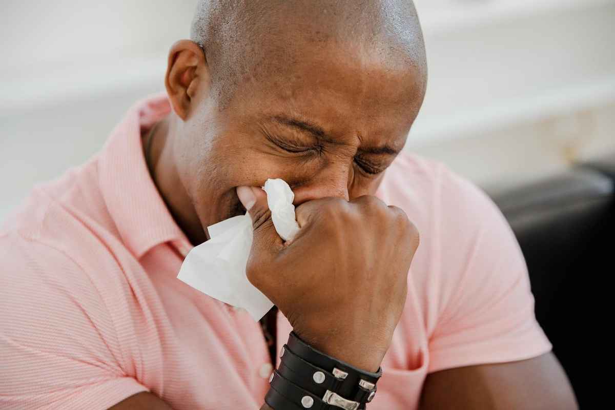 man crying while holding a piece of napkin