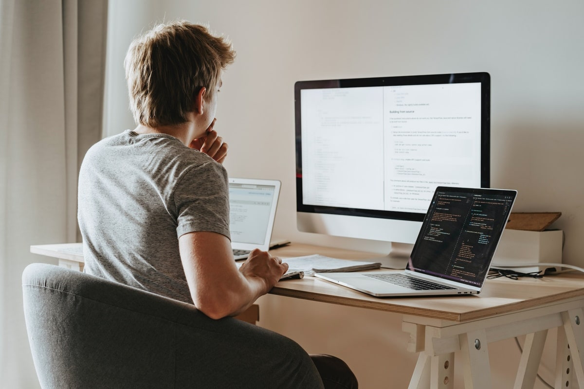 man staring at computer screens