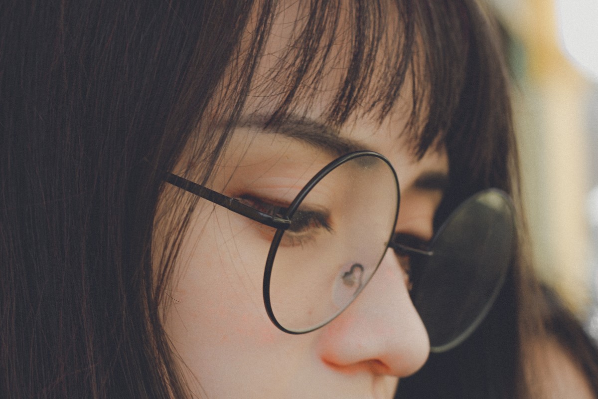 A girl wearing round glasses with nose pads