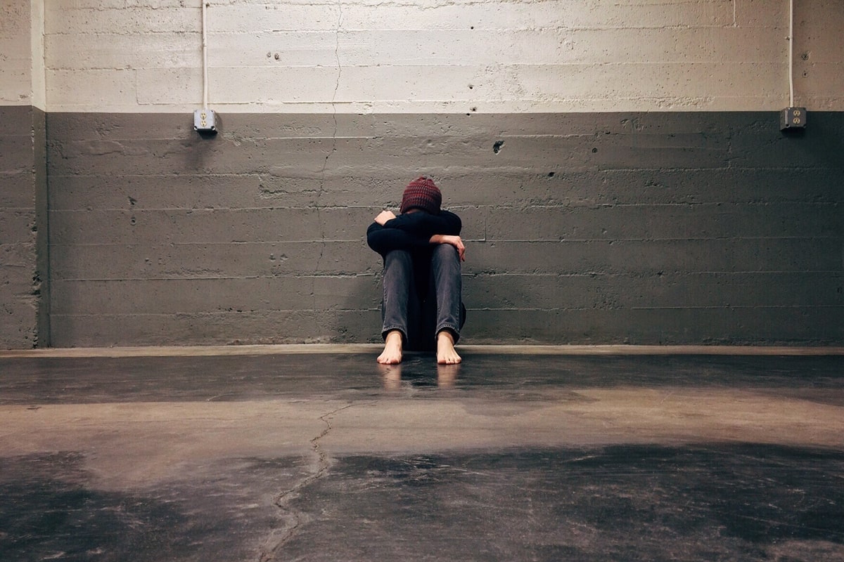 a person sitting by the wall experiencing anxiety