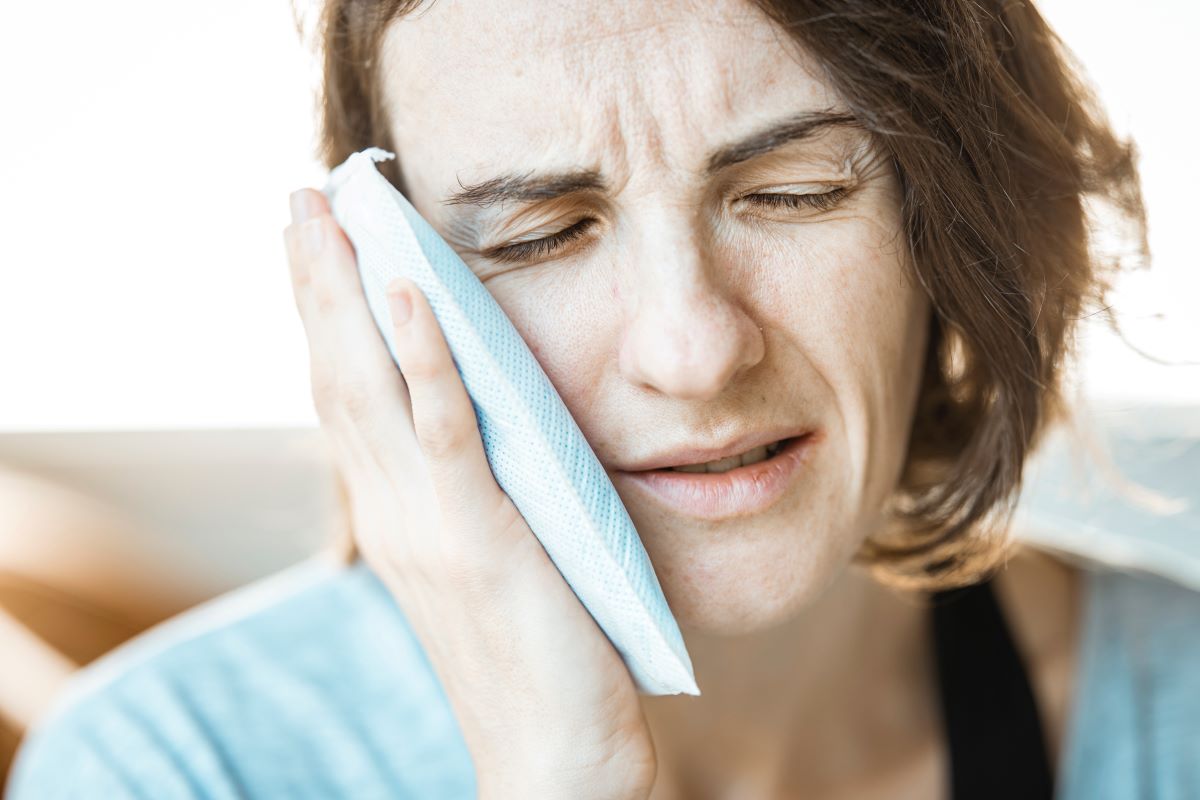 woman treating symptoms of petechiae with cold compression