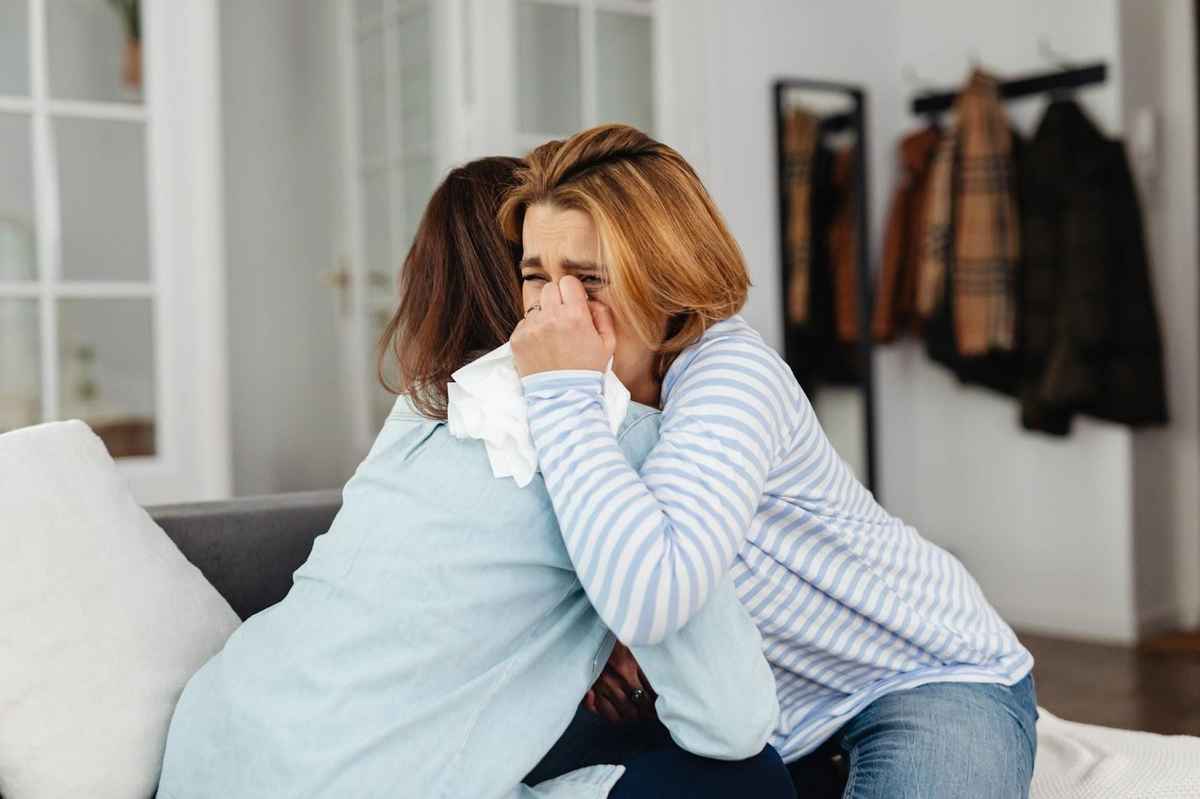blonde woman crying while hugging her therapist