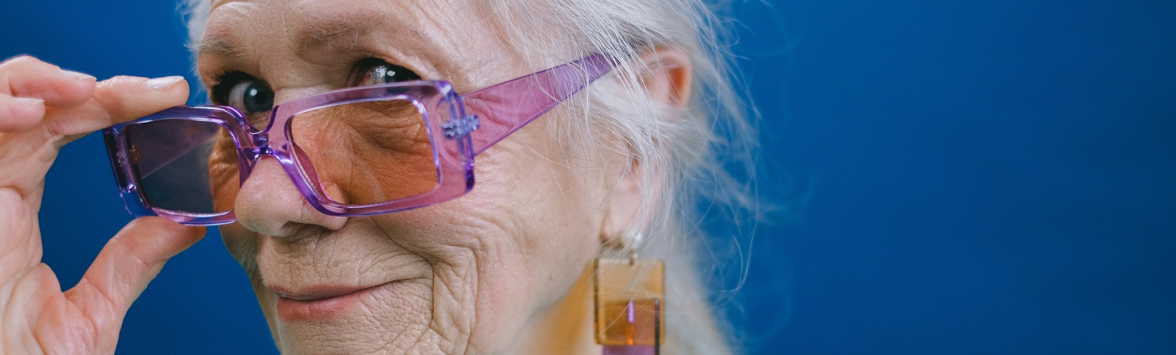 senior woman with gray hair wearing a pair of fashionable glasses