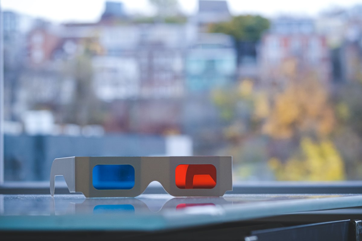 a pair of anaglyph 3d glasses placed by the car dashboard