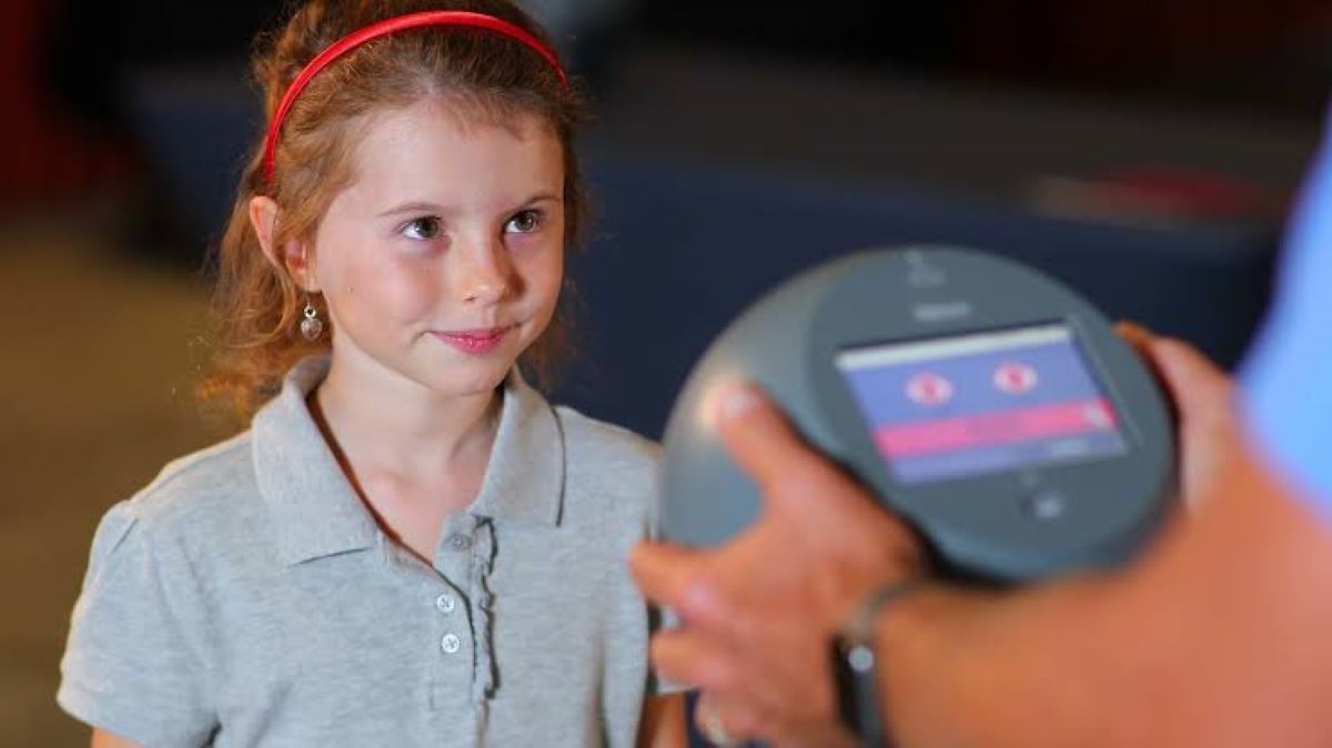 child about to be tested by vision scanner to detect abnormal bifoveal fixation