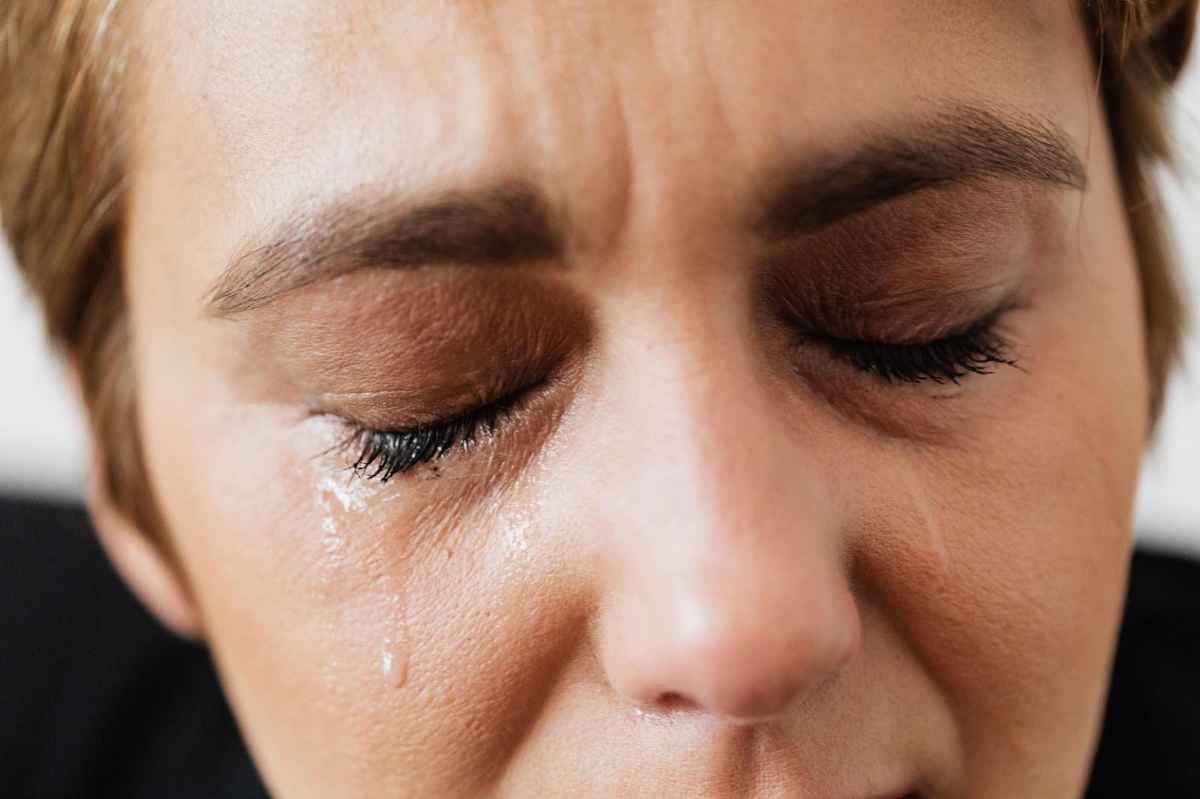 woman shedding tears with her eyes closed