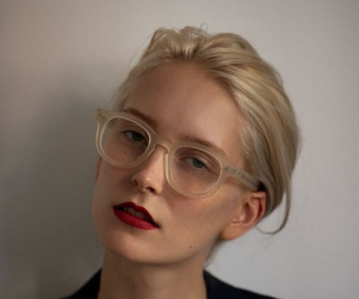 a blonde with red lips wearing a pair of acetate glasses frame
