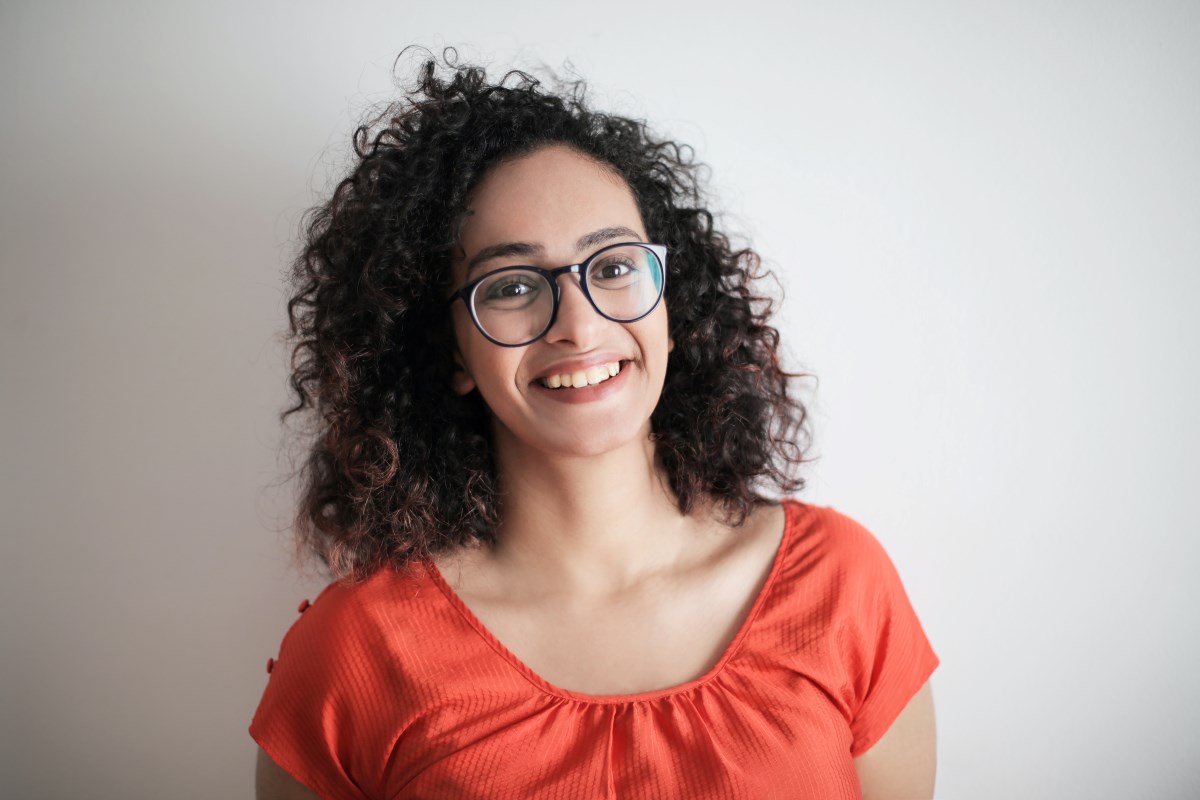 woman with curly hair wearing a pair of round glasses