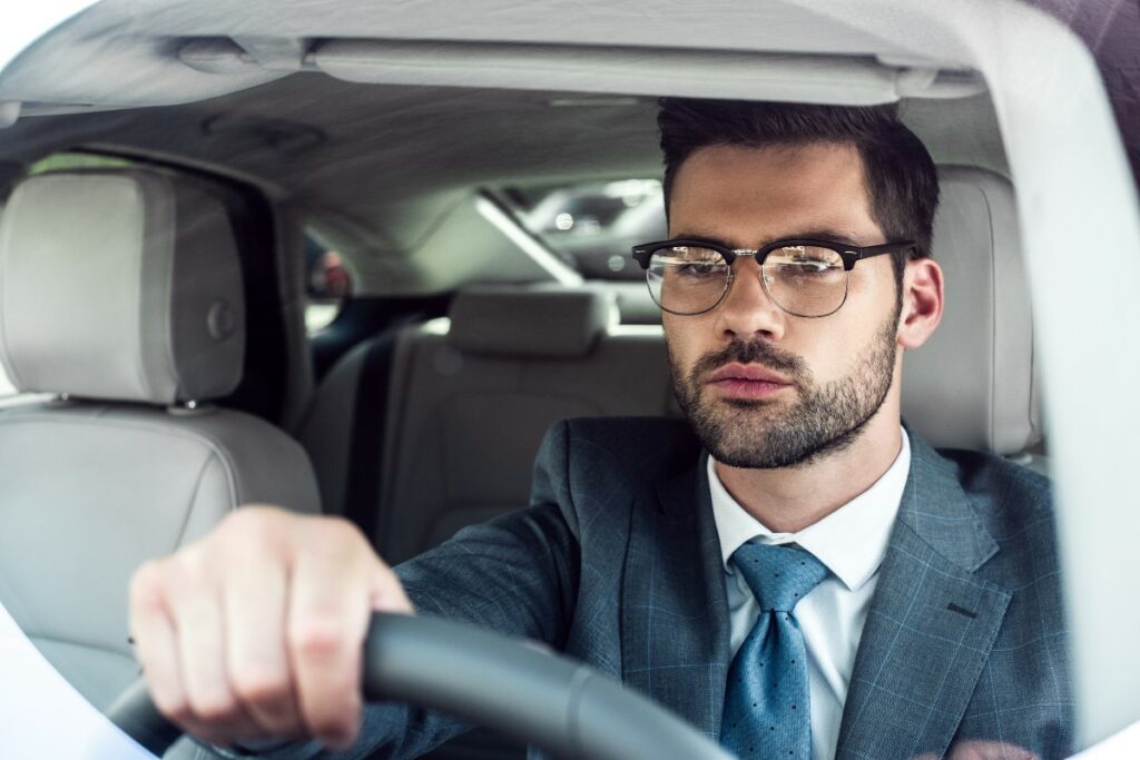man wearing glasses while driving