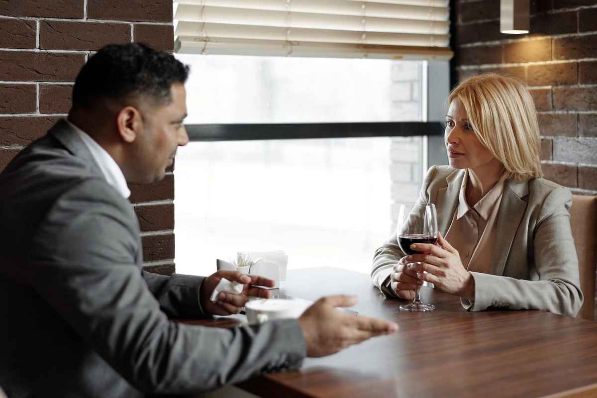 two people maintaining eye contact while conversing over wine