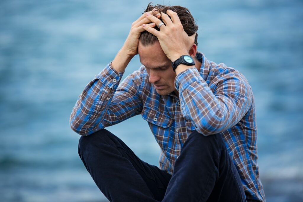 man putting pressure on his head to relieve headache