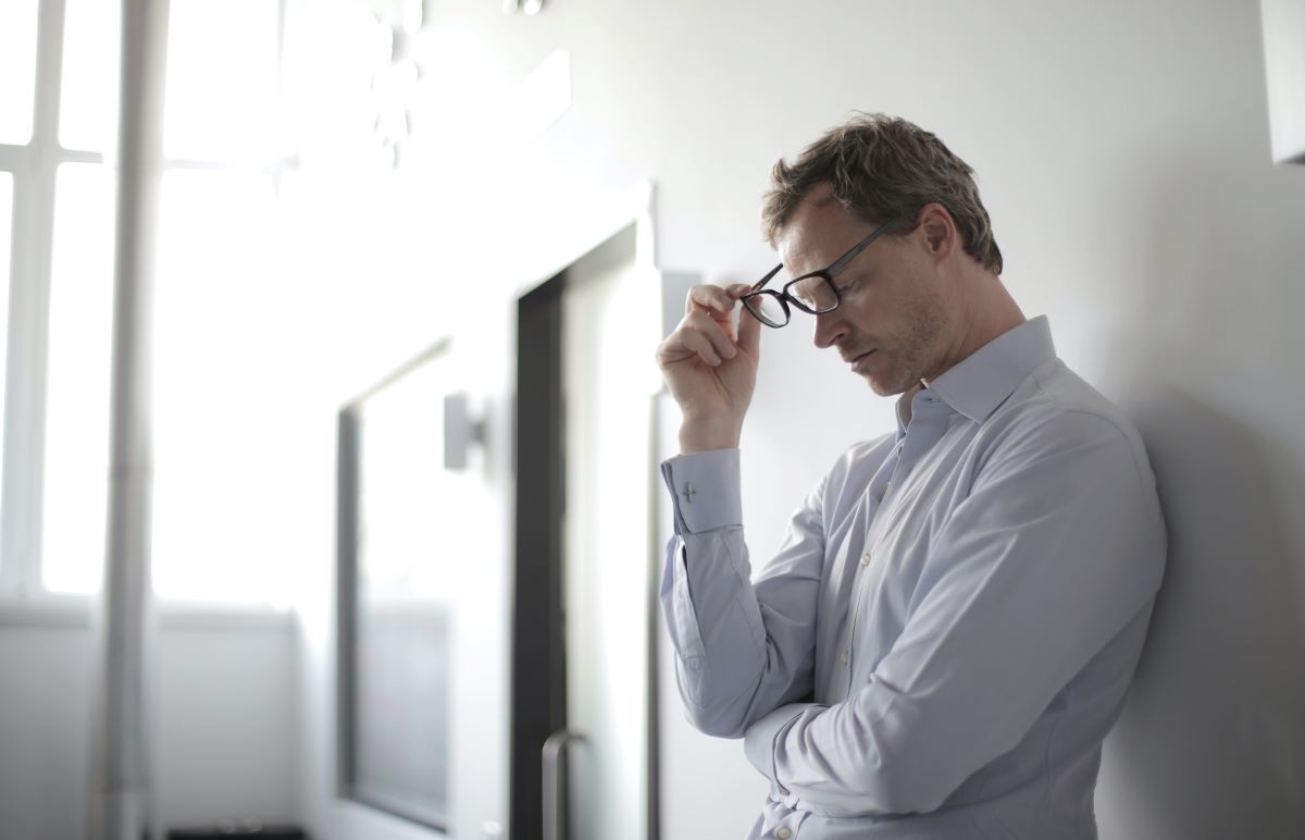 man with glasses looking tired from headache