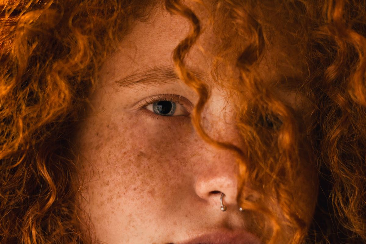 a redhead with curly hair and blue eyes