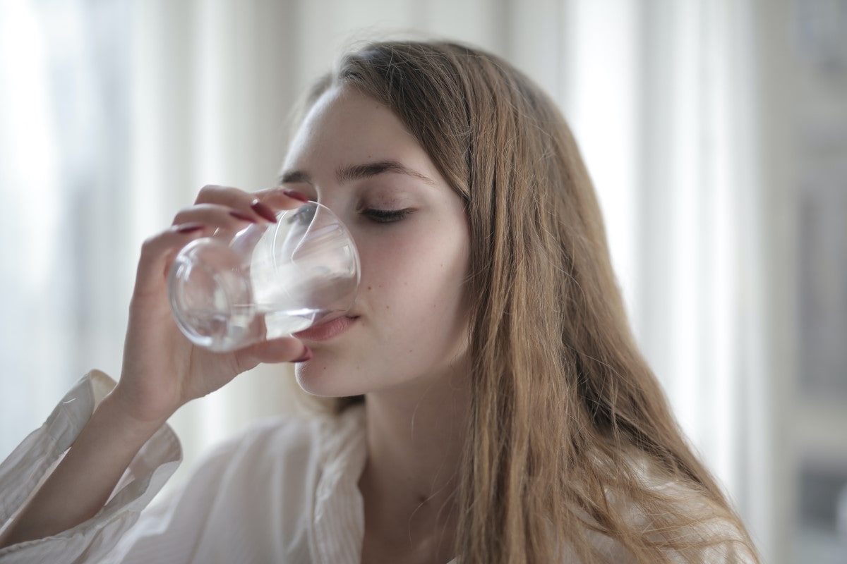 woman drinking water to relieve eye bags or puffy eyes