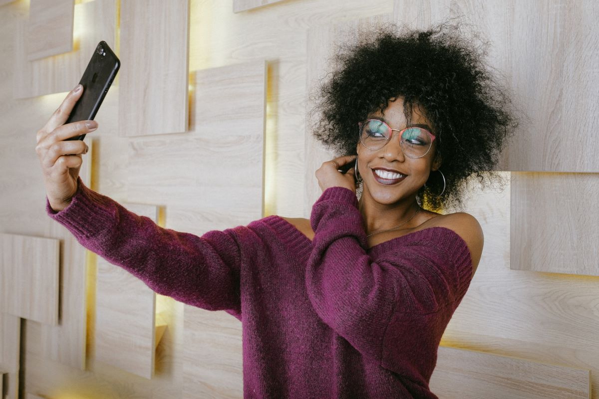 woman taking selfie at an angle to avoid eyeglass refelction