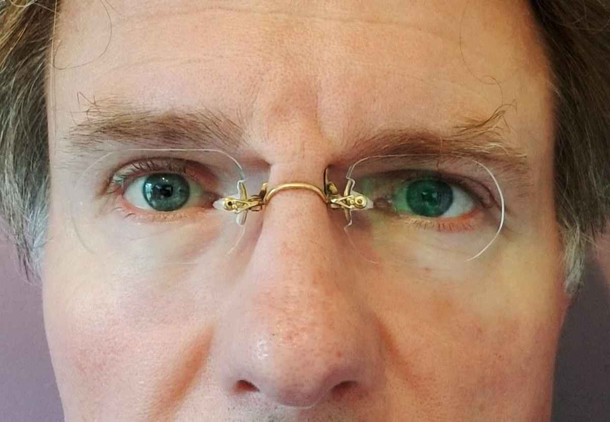 closeup of a face with a pair of pince-nez on