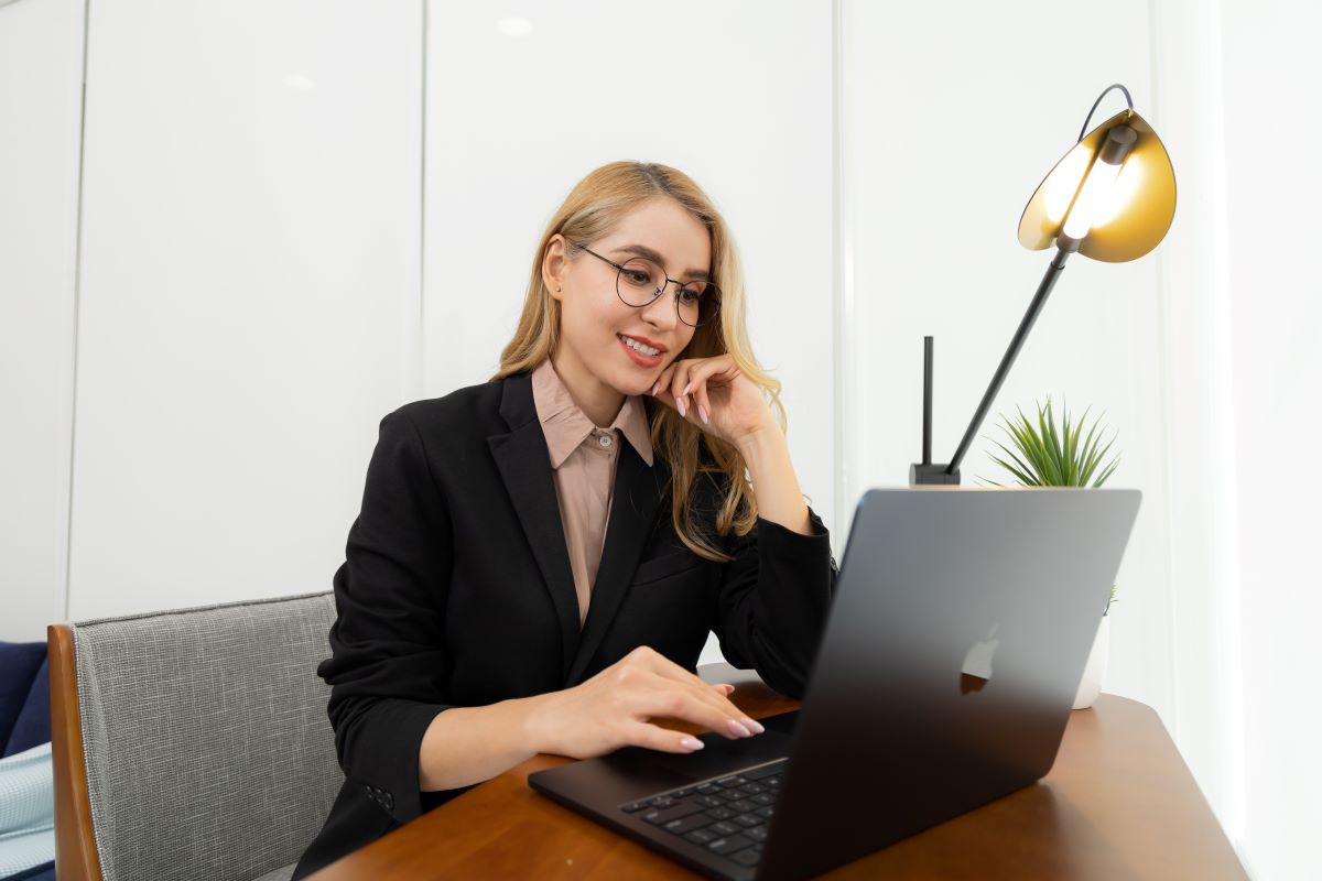 a woman wearing a pair of professional looking glasses while using the laptop