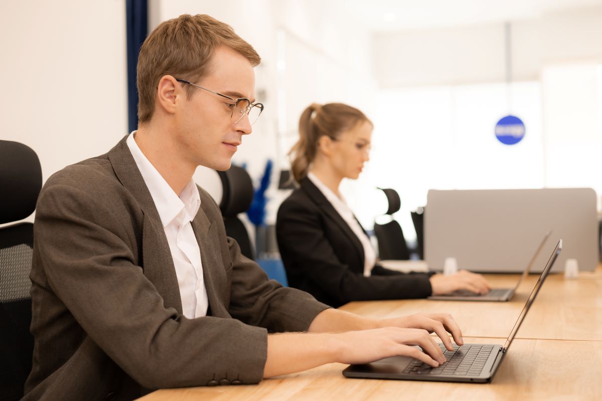 office workers wearing professional glasses while typing on their laptops