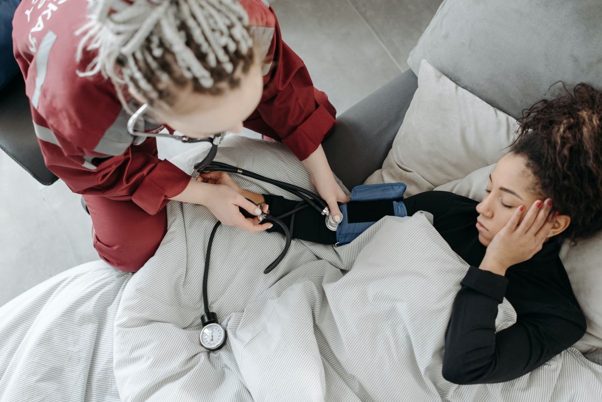 sick lady with headache being tested for blood pressure