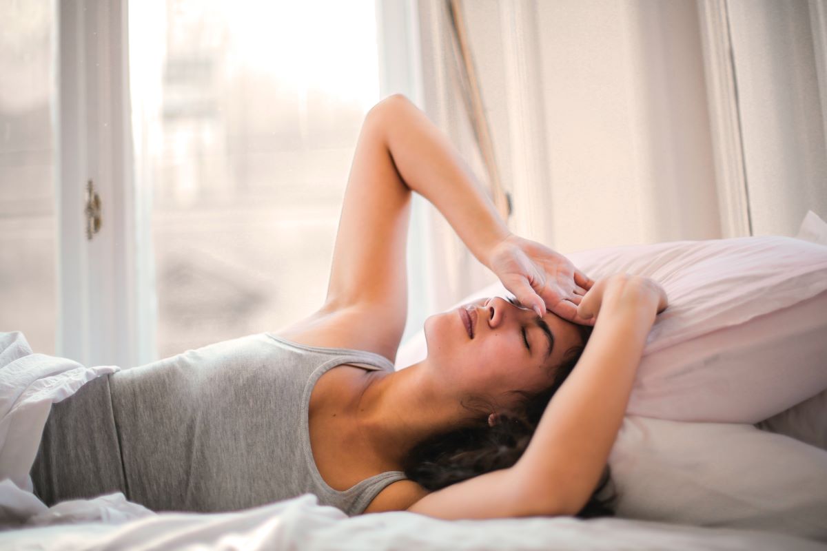 woman lying in bed having headache