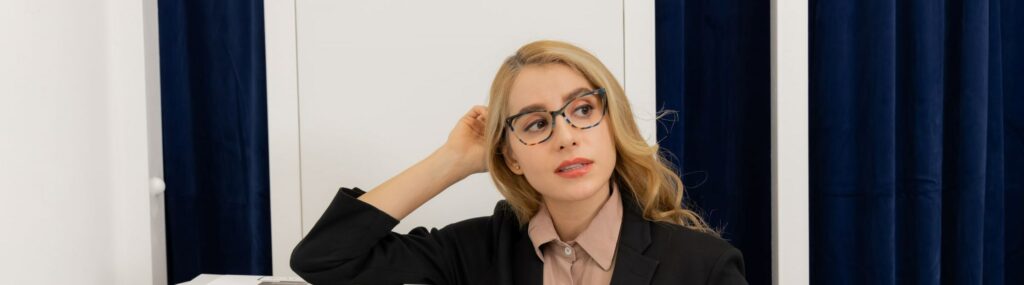 office staff wearing a pair of professional eyeglasses while waiting by the printer