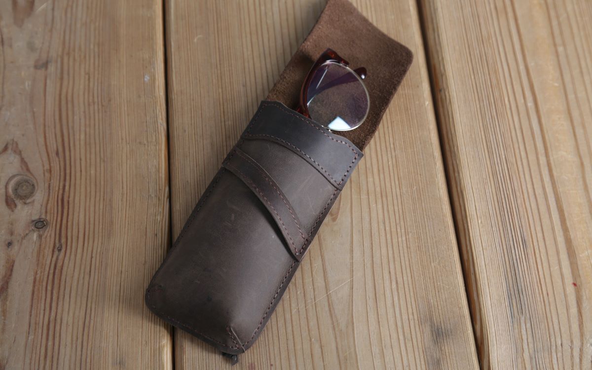 a pair of eyeglasses placed inside a leather pouch