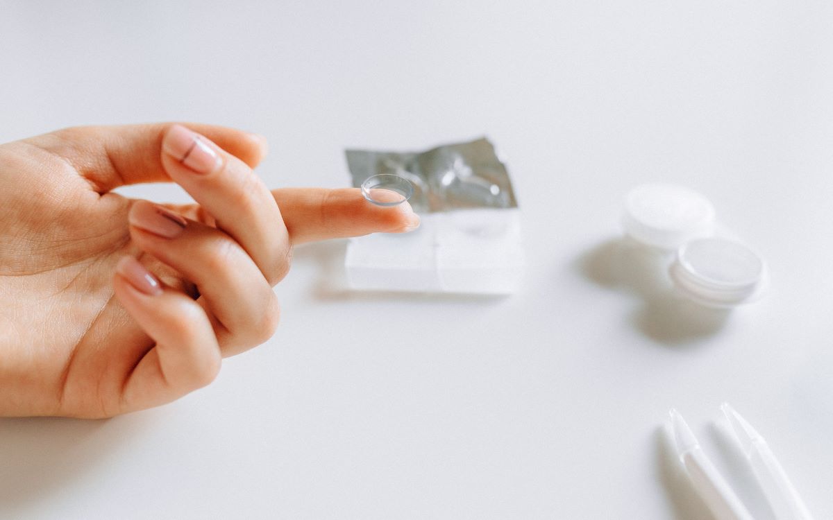 person holding a piece of contact lens by the fingertip