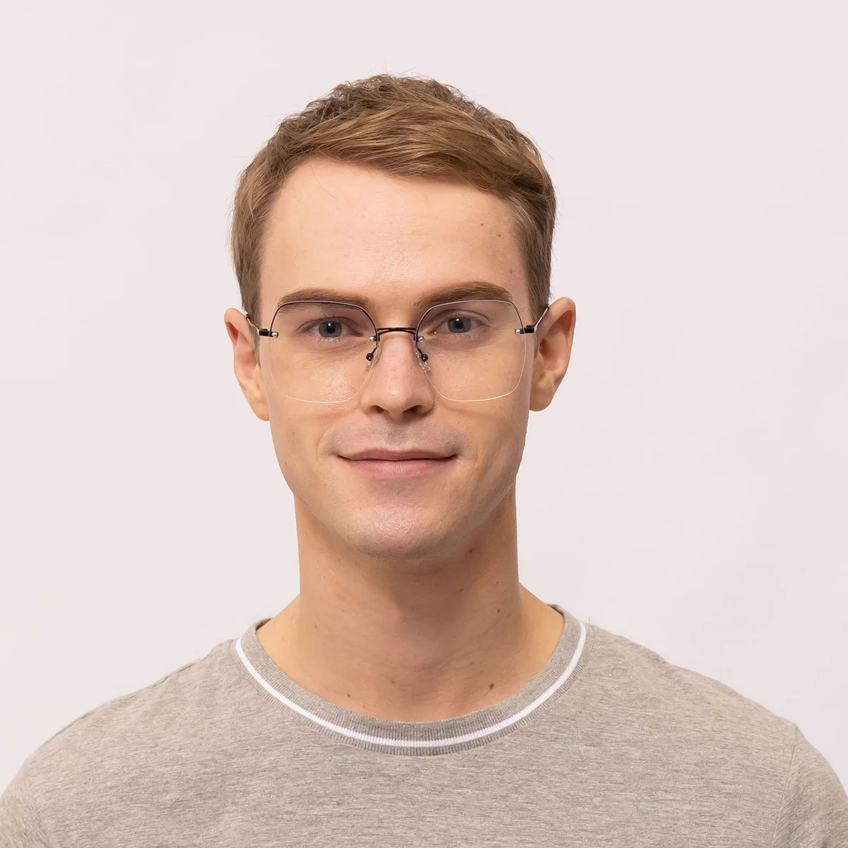 man wears rimless eyeglasses that makes his eyes appear bigger