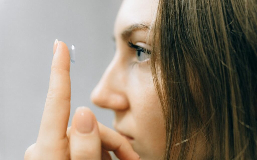 woman putting on contact lenses